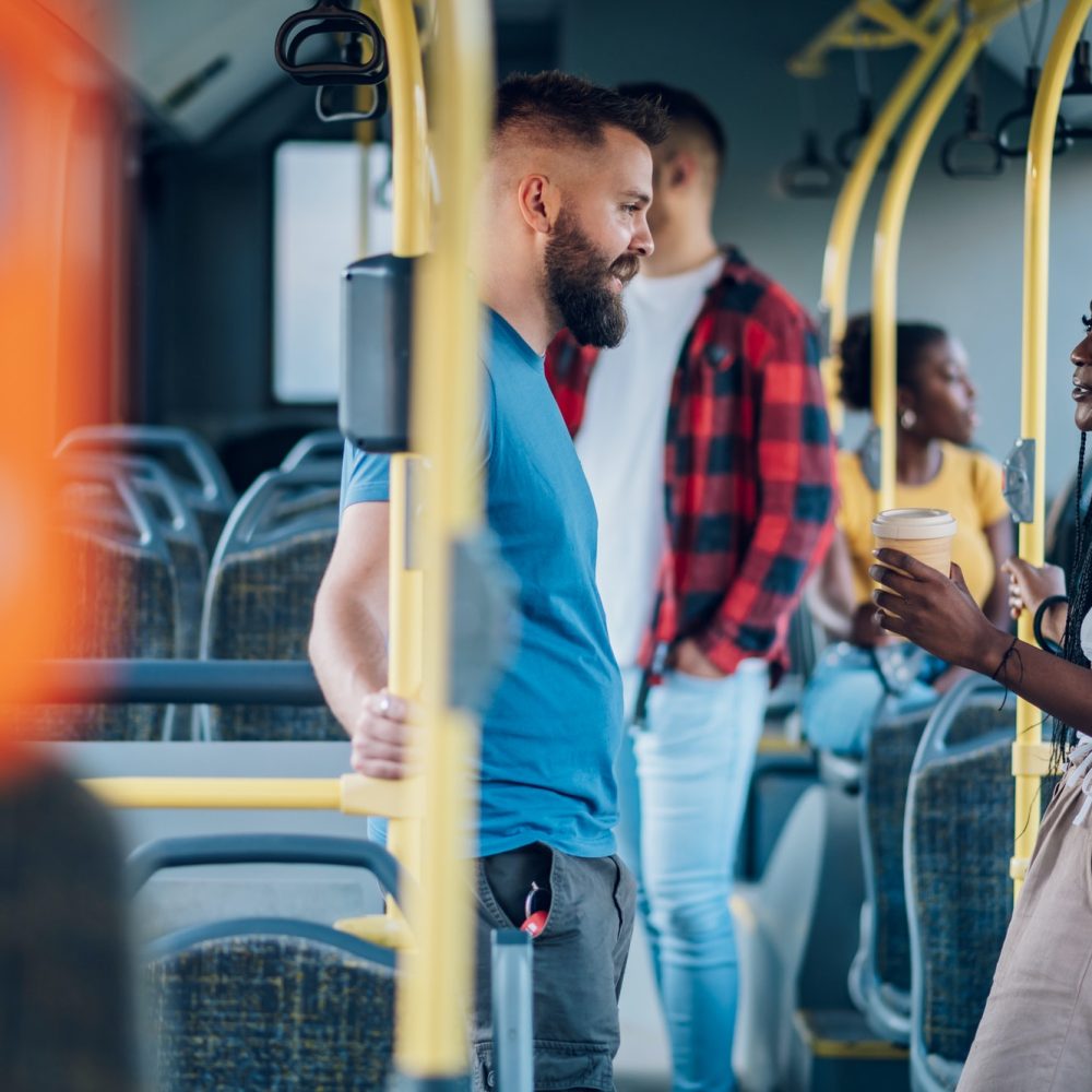 Multiracial friends talking while riding a bus in the city Multiracial friends talking while riding a bus in the city